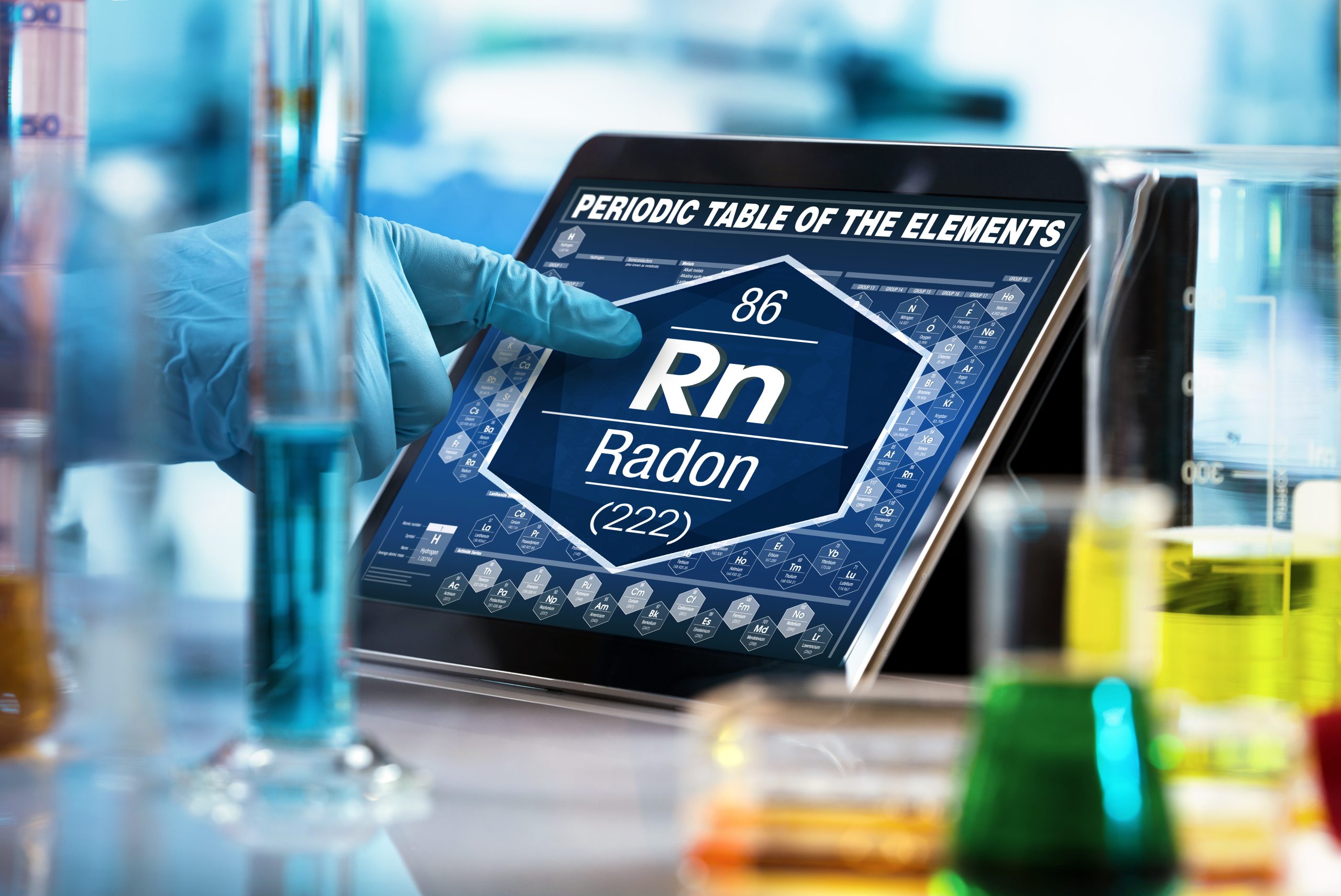researcher working on the digital tablet data of the chemical element Radon Rn / researcher consulting information on the computer of the periodic table of elements